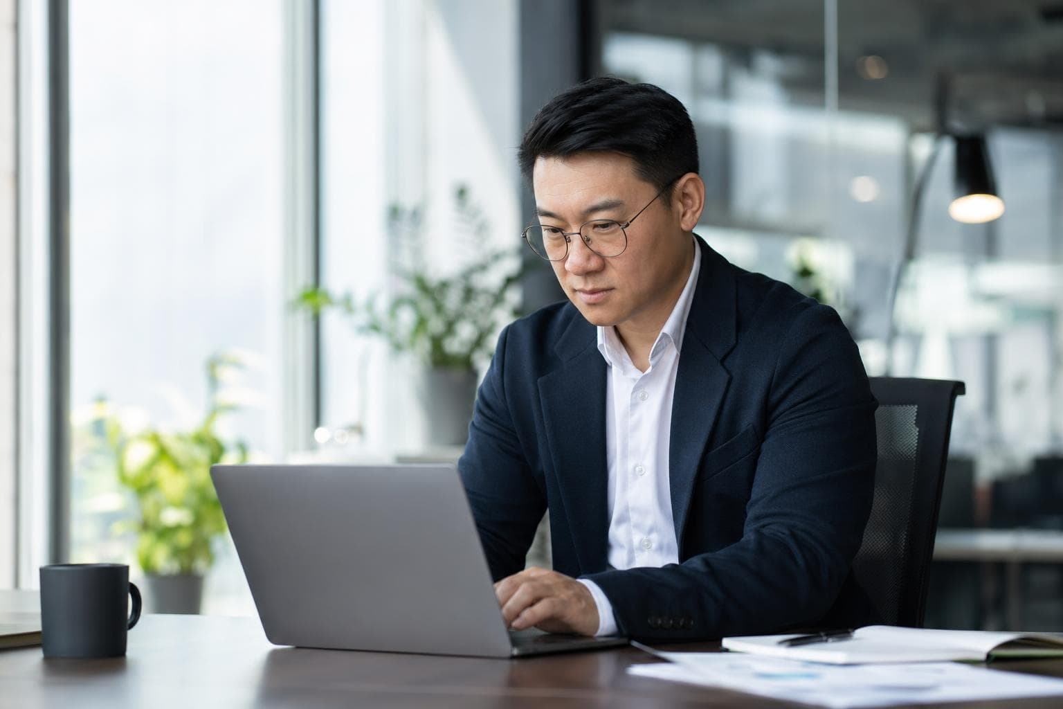 Professional data analyst working at a laptop in a modern office